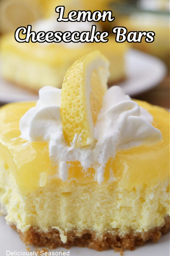 A close up photo of a lemon cheesecake bar on a white plate with a bite taken out with a fork.