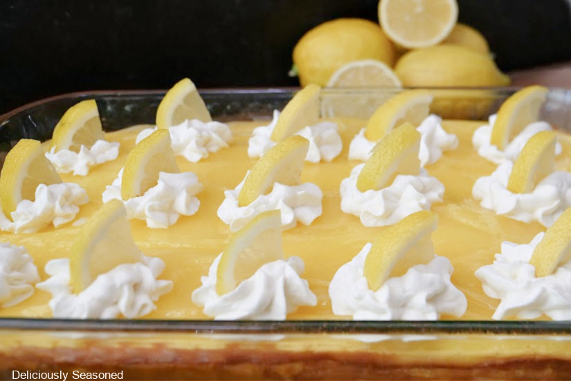 A horizontal photo of a 9 by 13 glass baking dish with lemon cheesecake bars in it before slicing.