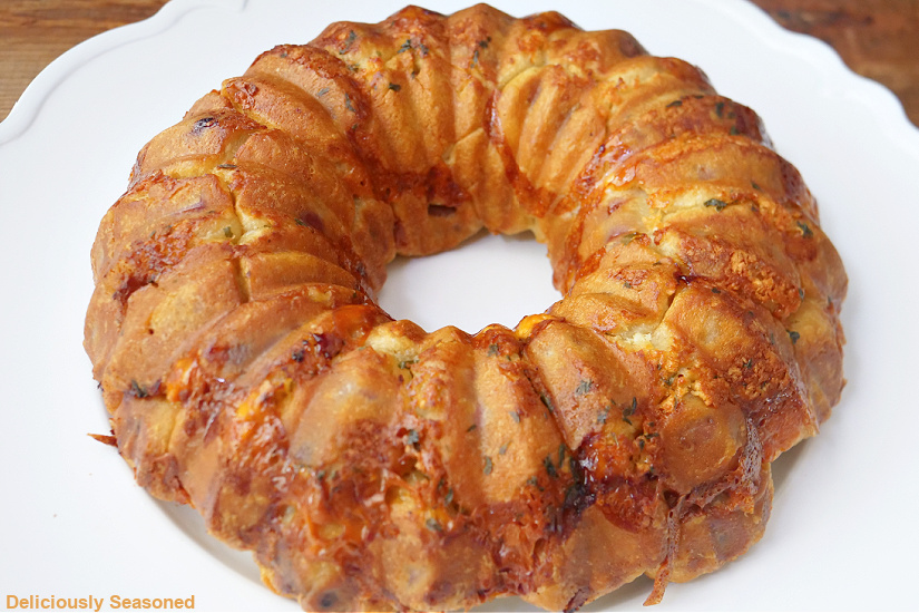 A horizontal photo of a golden brown monkey bread on a white plate.