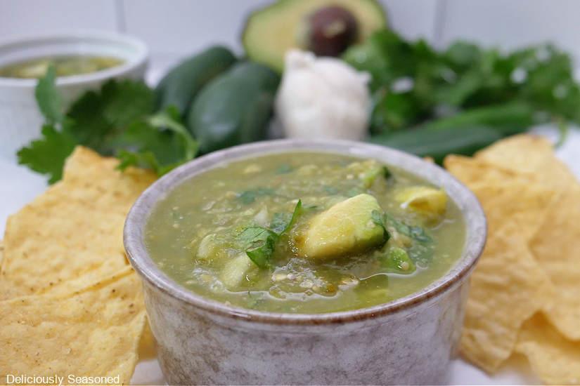 A horizontal photo of a gray bowl filled with green salsa.
