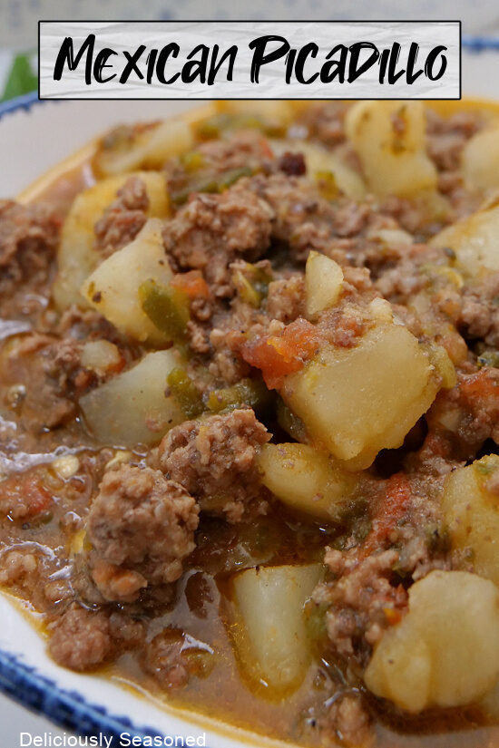 A close up of a bowl of ground beef with potatoes in a tomato and pepper sauce.