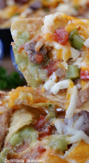 A tortilla chip filled with steak, cheese, onions, peppers and green sauce.