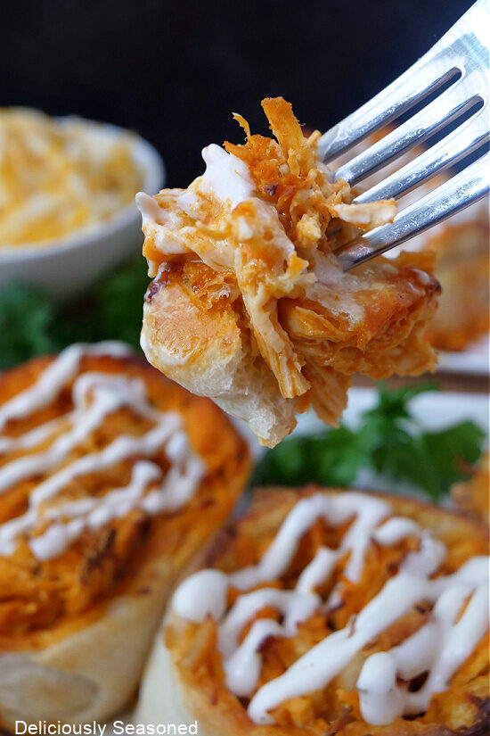 A close up of a bite of buffalo chicken pinwheel on a fork.