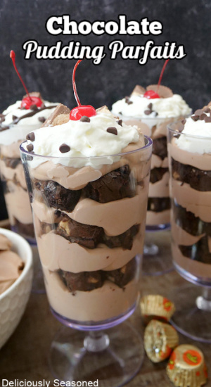 Four parfait glasses filled with bite-size brownie pieces and chocolate pudding.