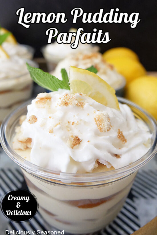 A small parfait cup filled with lemon pudding, lemon wafers, topped with whipped cream and a slice of lemon.