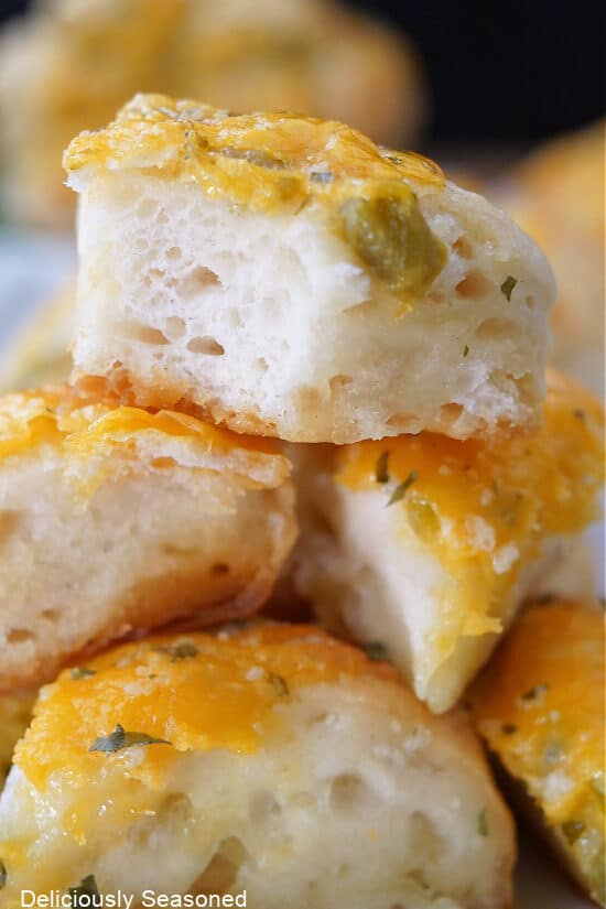 A close up of biscuit pieces with jalapenos and cheese.