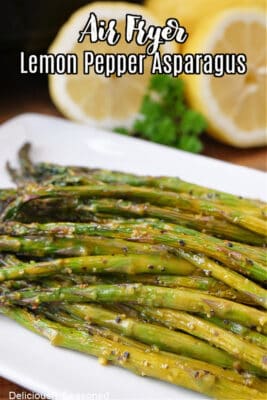A white oblong plate with lemon pepper asparagus on it.