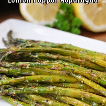 A white oblong plate with lemon pepper asparagus on it.