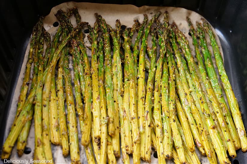 Asparagus in the air fryer basket after being air fried.