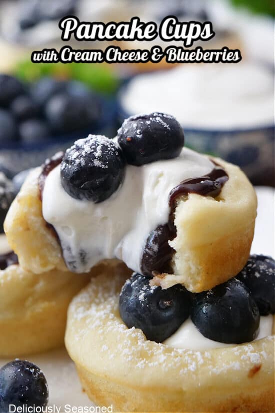 A close up of a pancake cup filled with cream cheese and blueberries.