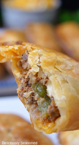 A close up of an empanada showing the inside ingredients.