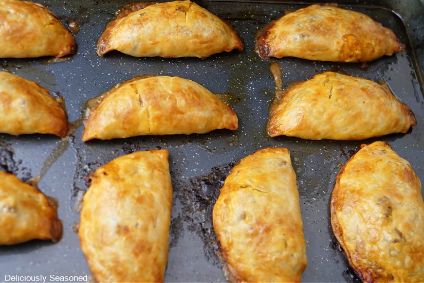 A baking sheet with 10 empanadas on it after being removed from the oven.