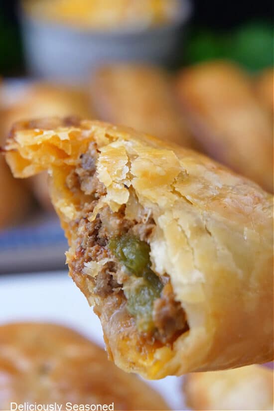A close up photo of a half beef empanada showing the inside ingredients.