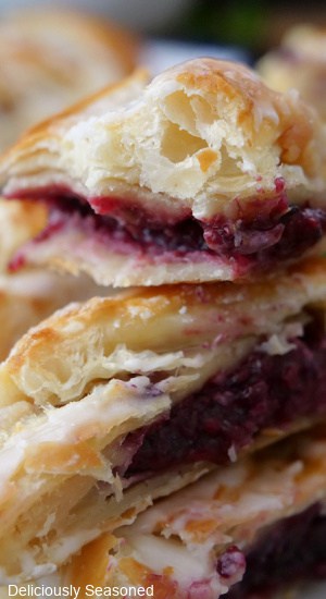 A close up of blackberry pastries with a bite taken out of one of them.