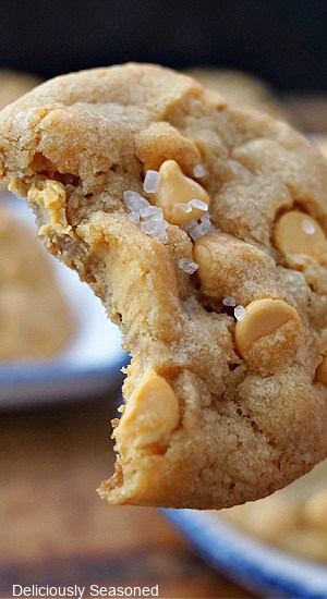 A close up of a butterscotch cookie with a bite taken out of it.