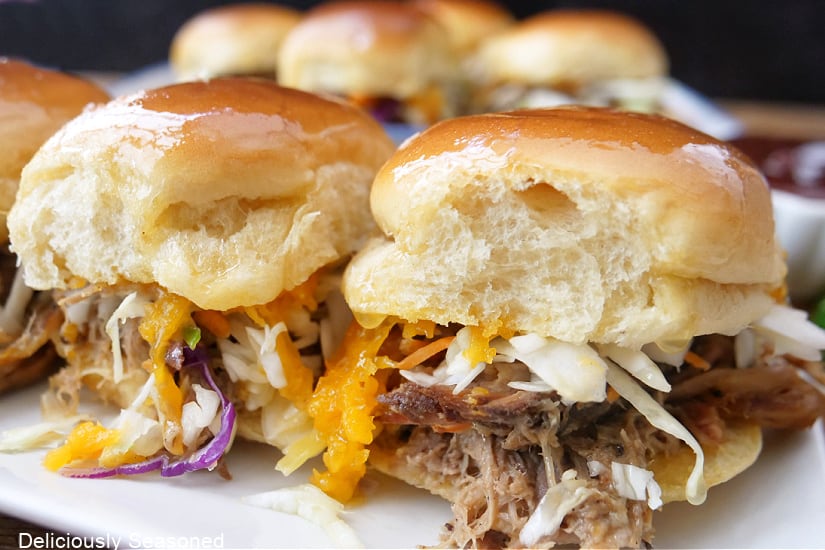 Pulled pork sliders on a white plate.