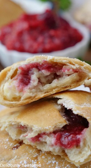 A raspberry empanada broke in half showing the fruit and cream cheese filling.