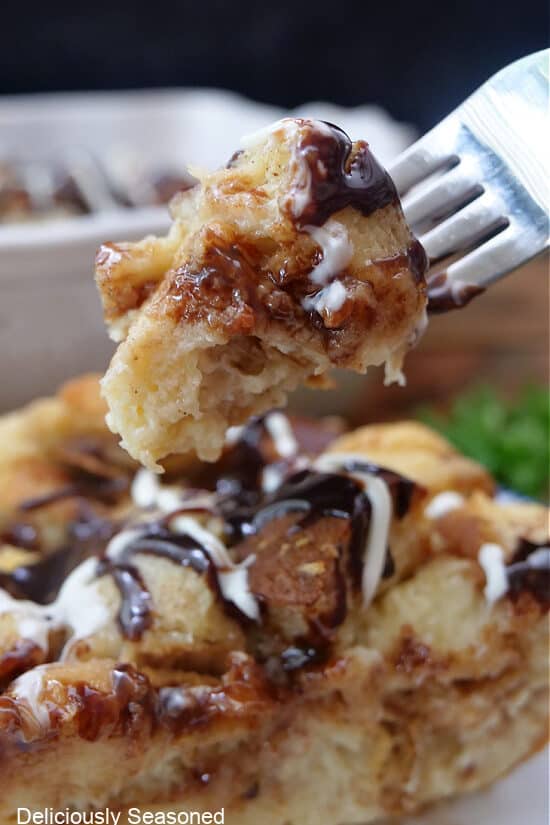 A fork with a bite of white chocolate bread pudding.