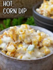 A grey bowl with a serving of hot corn dip in it.