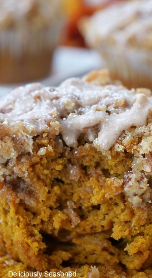 A close up of a pumpkin muffin with a bite taken out of it.