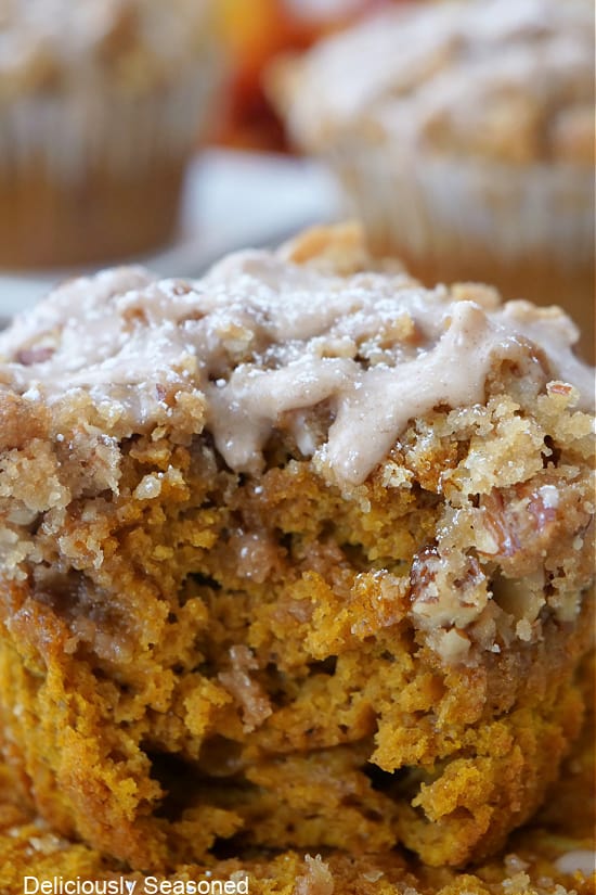 A close up of a pumpkin muffin with a bite taken out of it.