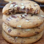 Four cookies with a bite taken out of the one on top.