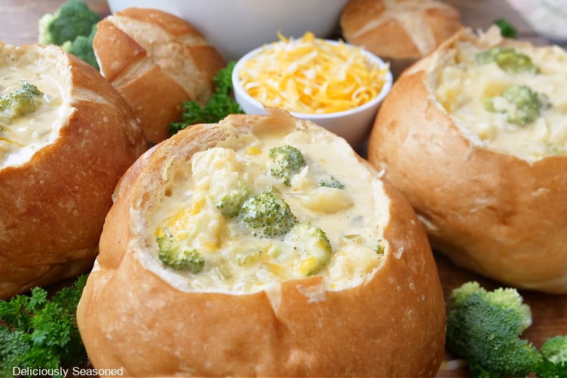 Three bread bowls filled with soup.