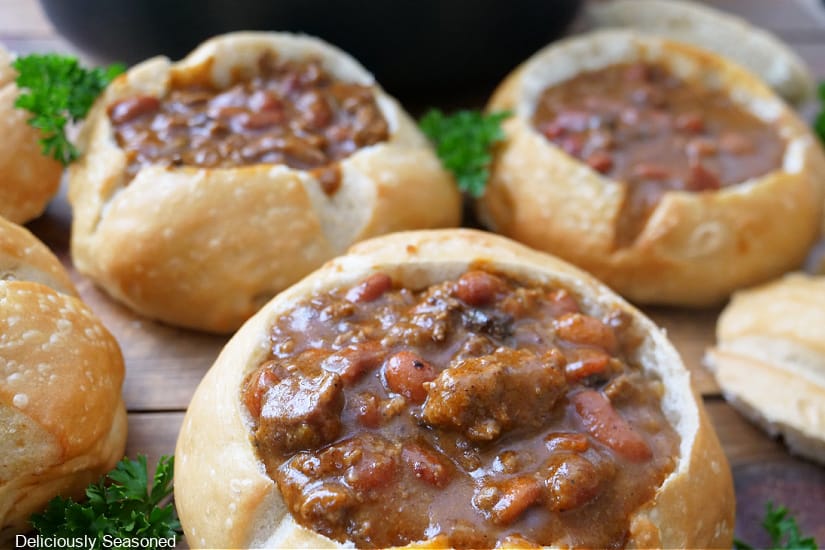 Three bread bowls filled with chili.