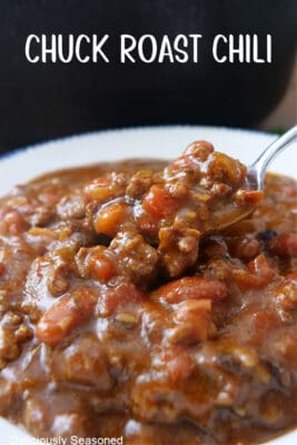 A bowl of chili with a spoon scooping a bite out.