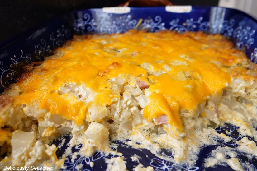 A baking dish with ham and cheese hash brown casserole in it.