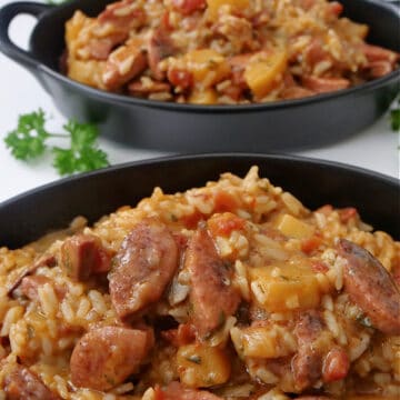 Two black oval serving bowls with sausage potato and rice in them.