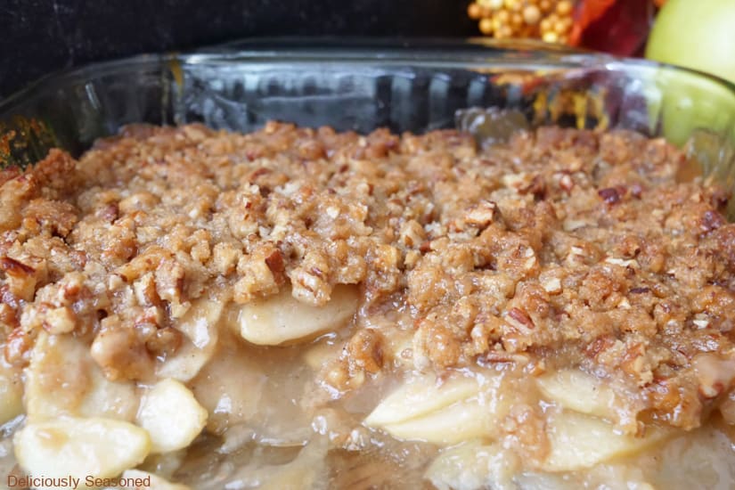 A glass baking dish with caramel apple crumble in it.