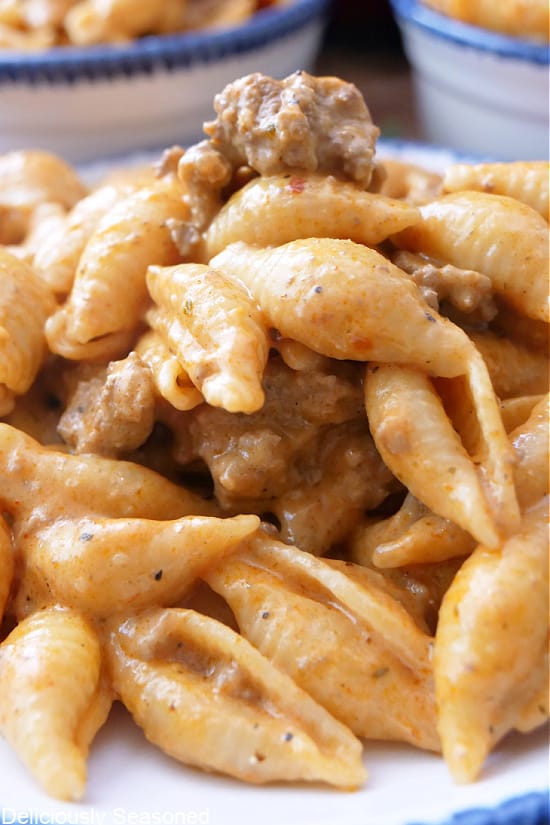 A close up pasta shells covered in a creamy sauce with ground beef.