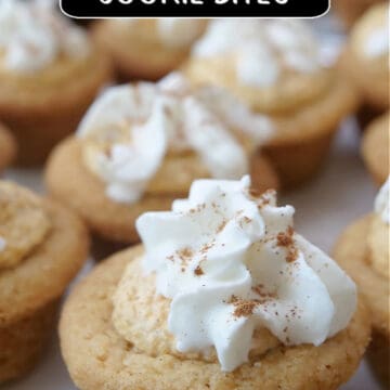 A white plate with bite-size cookie cups with pumpkin mousse and whipped cream on top.