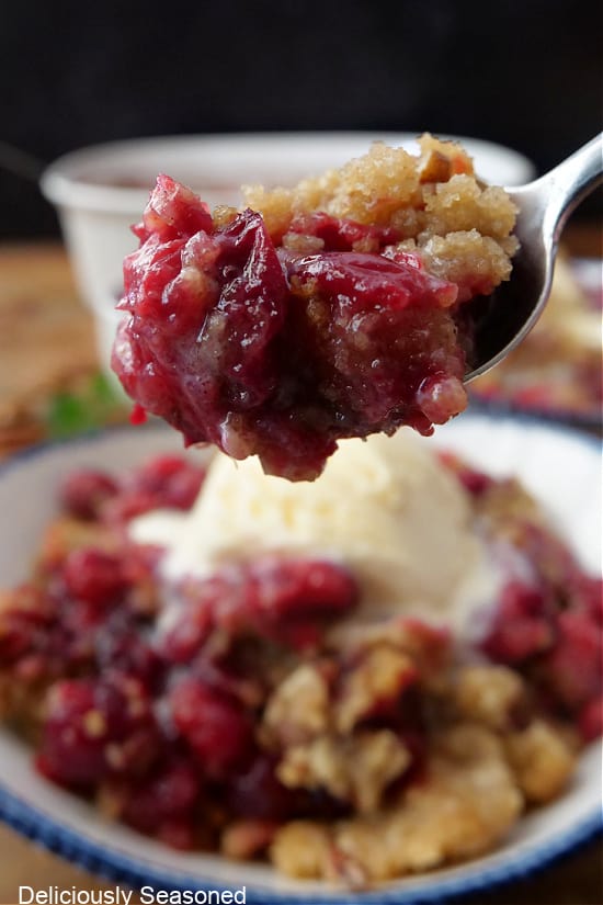 A close up of a spoonful of cranberry crumble.