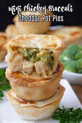 Three mini pot pies with chicken, broccoli and cheese stacked on top of each other with a bite taken out of one.