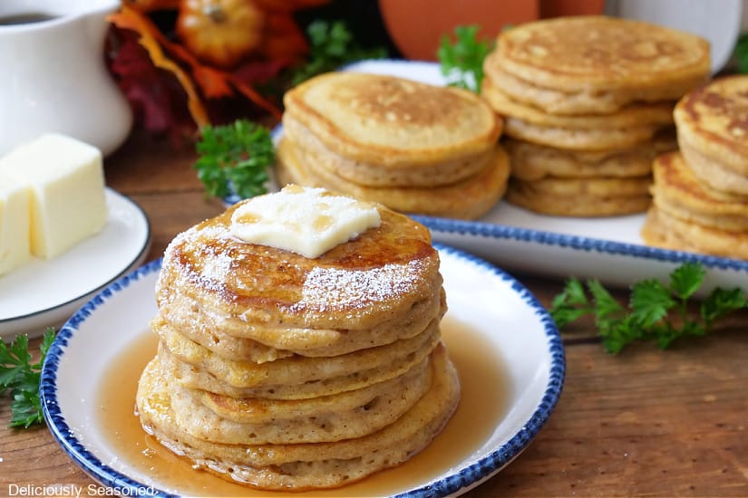 A horizontal photo of four stacks of mini pumpkin pancakes.