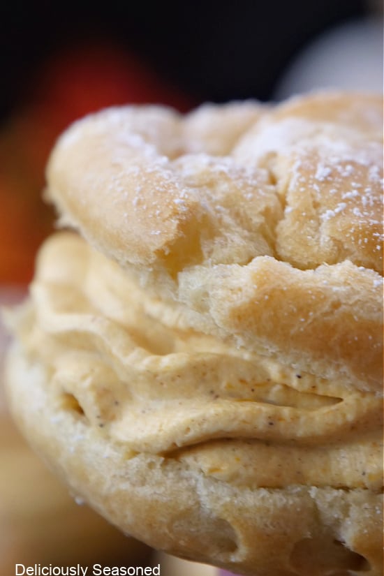A close up of a pumpkin mousse filled cream puff.