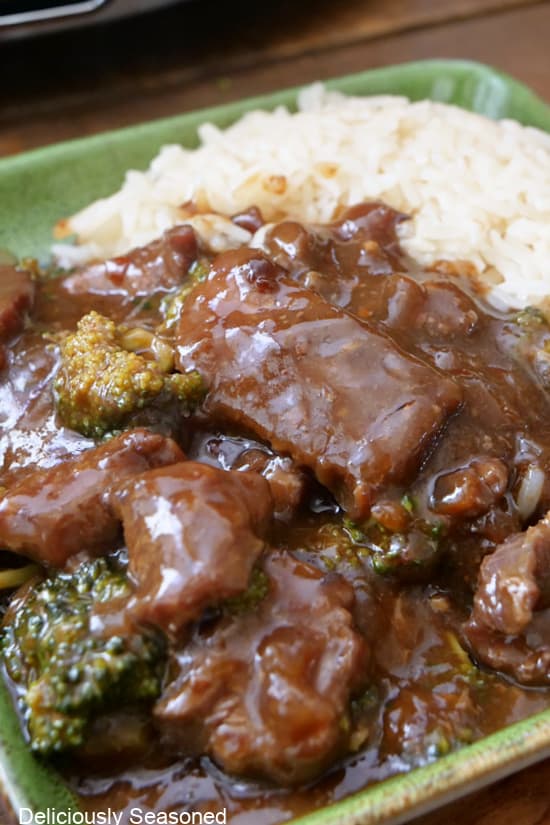 A close up of a plate with a serving of beef, broccoli, and rice.