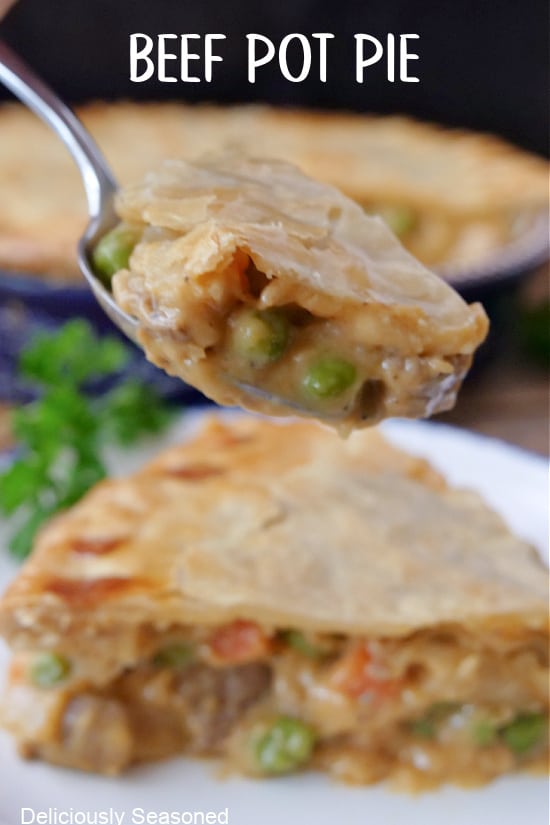 A close up of a bite of beef pot pie on a spoon.