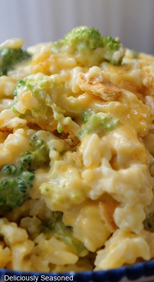 A close up of a serving of cheesy rice with broccoli.