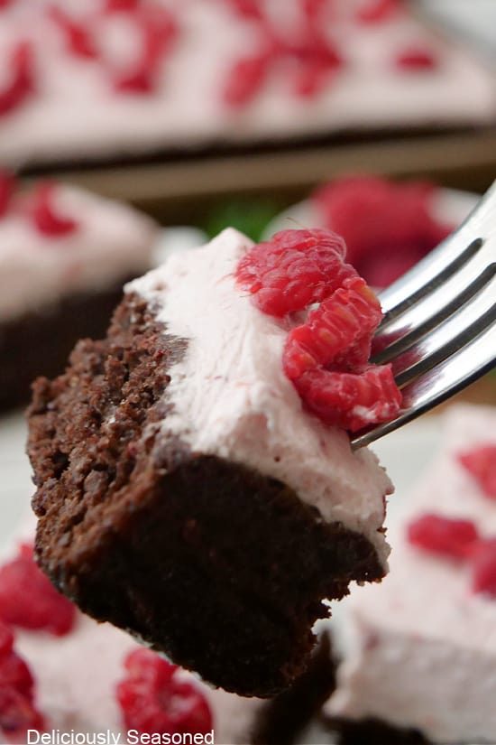 A close up of a bite of chocolate raspberry bar on a fork.