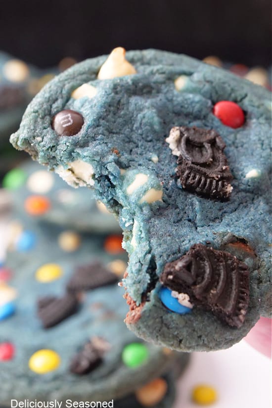 A close up of a blue cookie with a bite taken out of it.