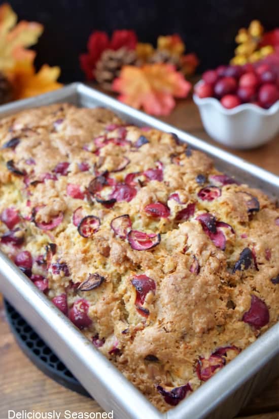 A metal baking pan with cranberry walnut bread in it.
