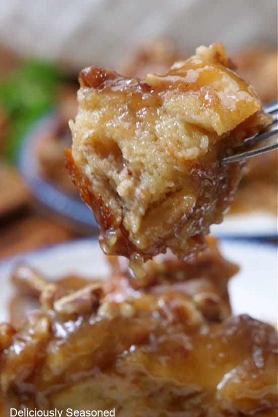 A close up of a bite of bread pudding on a fork.