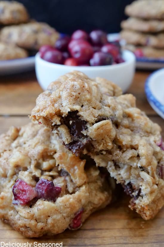 A close up of two oatmeal cranberry cookies with a bite taken out of one of them.
