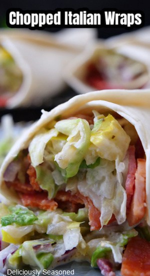 A close up of a flour tortilla filled with chopped meat and a lettuce mixture.