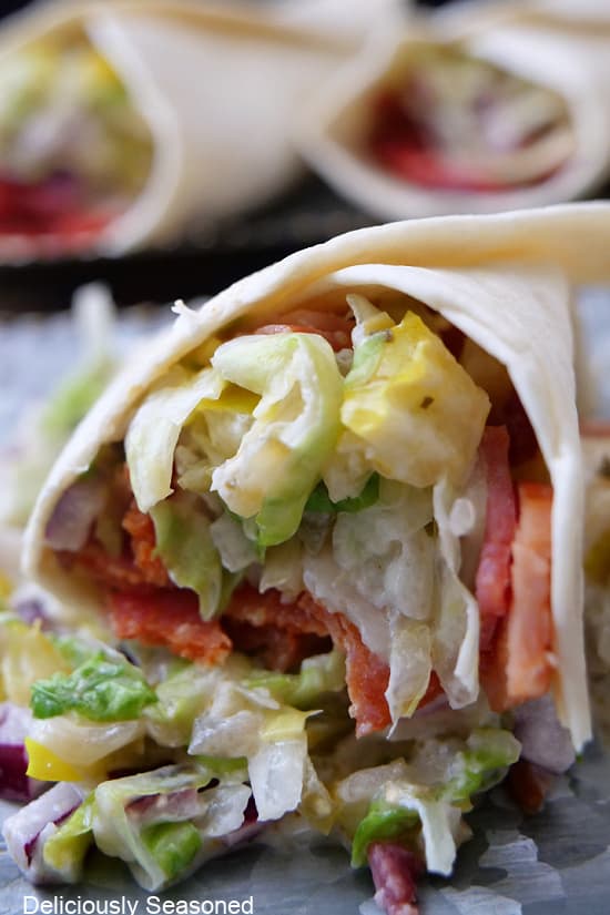 A close up of the filling ingredients of chopped meat and a lettuce mixture wrapped in a flour tortilla.