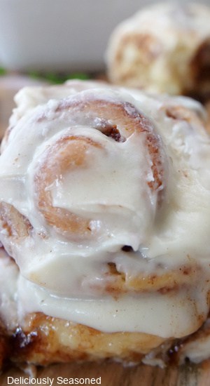 A close up of a cream cheese iced cinnamon roll.