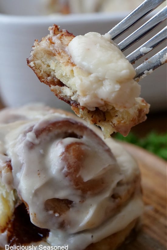 A bite of a cinnamon roll on a fork.